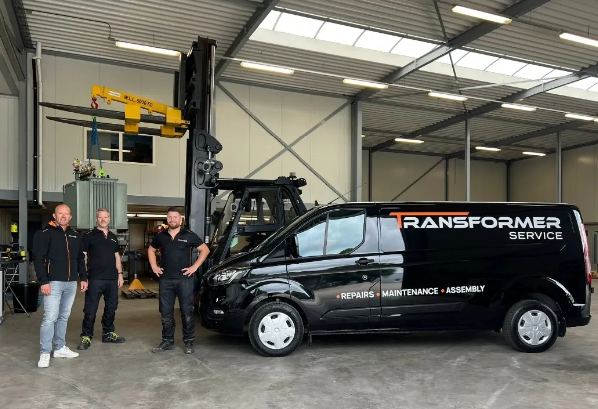 Het team van Transformer Service naast hun bedrijfswagen in de werkplaats in Westerlo.